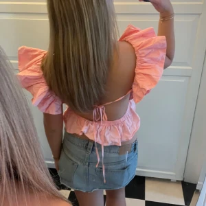 Rosa topp med volangärmar - Säljer denna superfina populära rosa topp med volangärmar och öppen rygg. Toppen har en jätte söt knytning i ryggen💓💓