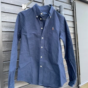 Ralph lauren skjorta - Det är en Ralph lauren skjorta i väldigt bra skick. Den är i bomull och det är vuxenstorlek i M. Ny pris ca 1300kr. Mitt pris 299kr.(kan passa S också sitter lite mindre i storleken än en vanlig M).