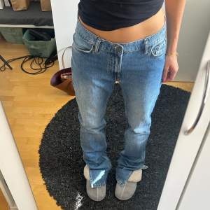 Jeans från Nelly med slitts längst ner i storlek 36