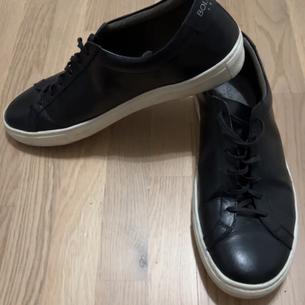 Säljer ett par stilrena svarta sneakers från Bolongaro Trevor. De är i skinn med en vit sula och har klassisk snörning. Perfekta för både vardag och fest, använda 2-3 ggr. Pris 299kr. Nypris 1600kr.. Skor.