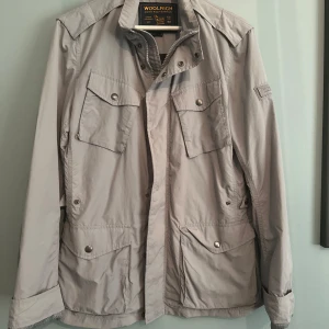 Woolrich fieldjacket - Tjena! Säljer min Woolrich fieldjacket till ett riktigt bra pris. Den är i 9/10 skick och har bara använts ett fåtal gånger. Jag är 182 cm, se bild 4 för referens. Nypris 4549 kr, du kan få den för 1299 kr. Hör av dig om du har några frågor! / Liam