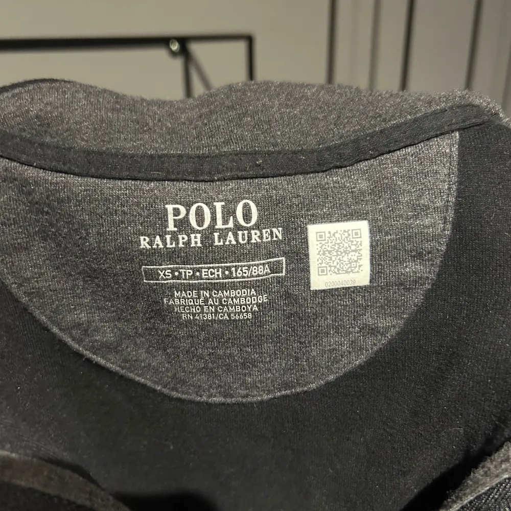 Säljer en stilren svart tröja från Polo Ralph Lauren i storlek XS. Tröjan har en halv dragkedja framtill och den klassiska loggan broderad på bröstet. Perfekt för både vardag och lite finare tillfällen. Den är i nyskick och superbekväm att ha på sig!. Tröjor & Koftor.