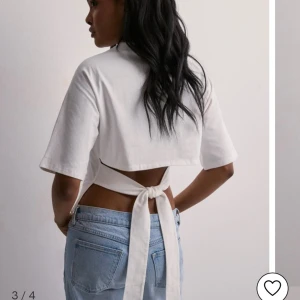 Knyt topp - Säljer denna skit snygga t- shirre från Nelly! Helt oanvänd. Själv brukar jag har storlek XS eller S men denna köpte jag i L då man knyter och kan justera själv och föredrar att den blev mer Trekvartsarmad! 