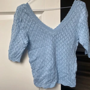 Ljusblå stickad topp - Säljer en superfin ljusblå stickad topp. Den har en v-ringad hals och trekvartsärmar