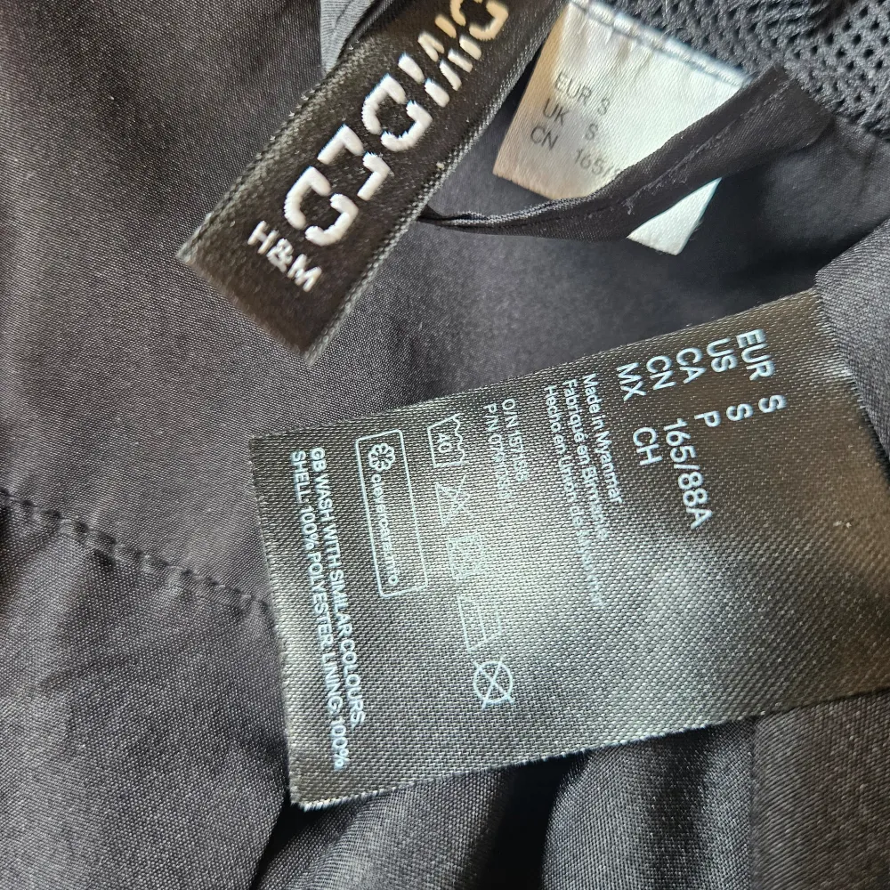 Säljer en svart vindjacka från H&M i storlek S. Jackan har en dragkedja framtill och en justerbar huva med dragsko. Perfekt för blåsiga dagar! Den är i bra skick och har elastiska muddar vid ärmsluten för extra komfort.. Jackor.