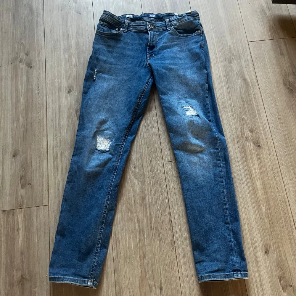 Säljer dessa riktigt snygga jeans från Jack N Jones, sitter bra med slitningar. Jeansen är i slimfit Glenn och passar dom med 28/30. Priset är inte hugget i sten så hör gärna av er vid intresse eller funderingar.. Jeans & Byxor.