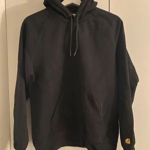 Svart hoodie från Carhartt - Säljer en svart hoodie från Carhartt i storlek S med klassisk design och känguruficka. Justerbar huva och ribbade muddar. 