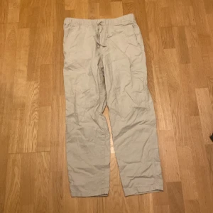 Beige byxor från H&M - Säljer ett par beige linnebyxor från H&M i relaxed fit. Byxorna har en bekväm passform med snörning i midjan. Perfekta för sommaren. Använde ett par gånger. Mitt pris 100kr