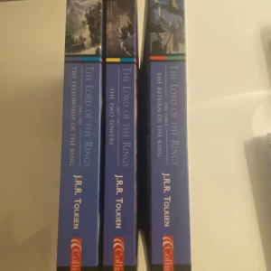 The Lord of the Rings Bok Set - Säljer en box med 'The Lord of the Rings' av J.R.R. Tolkien. Innehåller 'The Fellowship of the Ring', 'The Two Towers' och 'The Return of the King'. Böckerna är på engelska med en modern klassikerutgåva och illustrerade omslag.