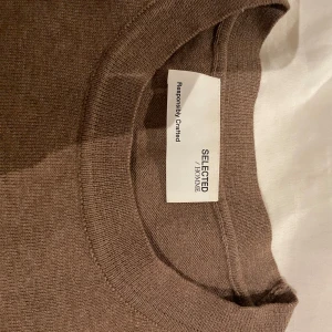Brun tröja från Selected Homme - Säljer en stilren brun tröja från Selected Homme. Tröjan har en klassisk rund hals och långa ärmar, perfekt för en avslappnad look. Tillverkad i ett mjukt material som känns skönt mot huden.