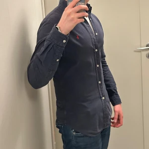 Ralph Lauren Skjorta - Säljer en riktigt fet Ralph Lauren Skjorta i marinblå färg. Storlek slim fit S. Skjortan är lite urtvättad så färgen har blivit lite ljusare. Snabb affär bättre pris. Om du har några funderingar så är det bara att fråga på! ❇️