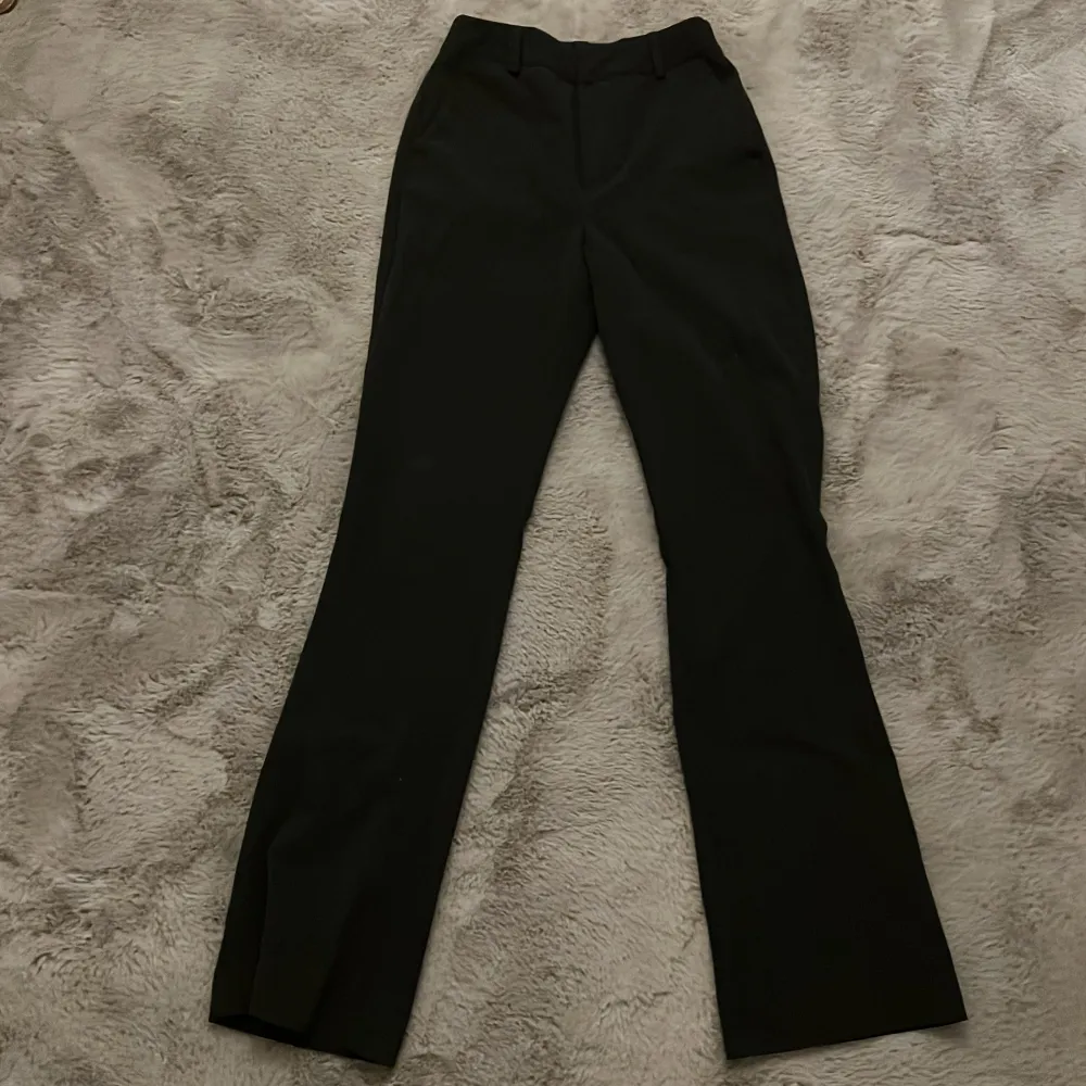 Snygga mörkgrå kostymbyxor från BikBok i en klassisk design. Byxorna har en hög midja och en rak passform som ger en stilren look. Perfekta för en chic och elegant stil. . Farkut & Housut.