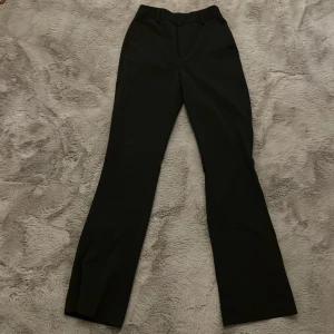 Mörkgrå kostymbyxor från BikBok - Snygga mörkgrå kostymbyxor från BikBok i en klassisk design. Byxorna har en hög midja och en rak passform som ger en stilren look. Perfekta för en chic och elegant stil. 
