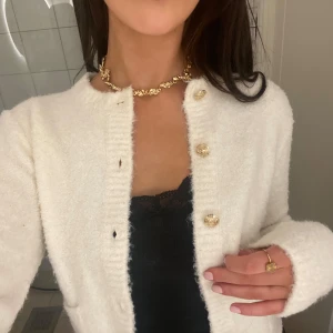 Superfin old money kofta med guldknappar - ORGINALPRIS 599, säljer för 70% av priset! Säljer en stilren vit kofta med glittriga guldknappar. Koftan har en mjuk och fluffig textur, perfekt för att hålla sig varm och snygg. Den har långa ärmar och en klassisk rund halsringning. 