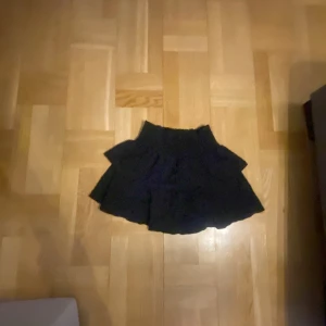 Svart kjol från Shein - Snygg svart kjol från Shein i kort modell. Perfekt för en stilren look. Kjolen har en volangdetalj som ger extra flärd.