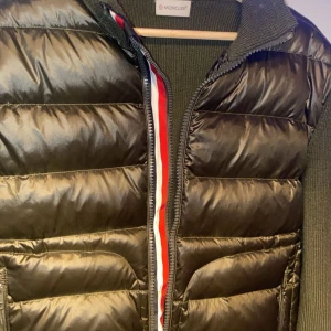 Moncler cardigan - Säljer en snygg olivgrön cardigan från Moncler med stickade detaljer. Jackan har en quiltad design och dragkedja framtill. Köptes från Plick tidigare , har legit checkats och ser bra ut men man vet aldrig nuförtiden(därav priset) Rintigt fet cardigan kommentera för frågor⚡️💫 Byten kan va intressant ✅