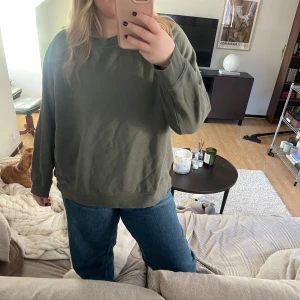 Olivgrön sweatshirt - Säljer en olivgrön sweatshirt med rund hals och långa ärmar. Perfekt för en avslappnad stil och passar bra till jeans.