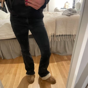 Low waist bootcut jeans - Snygga svarta jeans med en tight passform. De har en klassisk design med fem fickor och knappgylf. Perfekta för en stilren look.