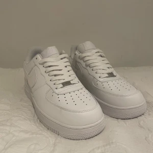 Vita Nike Air Force 1 sneakers - Säljer ett par klassiska vita Nike Air Force 1s. De är i ett riktigt bra skick med bara några enstaka minimala smuts fläckar. Allt syns på bilderna.