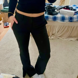 Svarta bootcut kostymbyxor från Bikbok  - Snygga svarta kostymbyxor med en klassisk bootcut-stil. De har en låg midja och har designade fickor där bak. Perfekta för en stilren look. Byxorna är små i storleken och skulle därför klassas mer som XS/34 fast det står att dem är S/36.