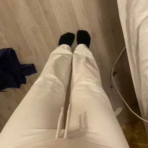 Vita mjukisbyxor med snörning - Säljer ett par bekväma vita mjukisbyxor med snörning i midjan. Perfekta för en avslappnad stil och sköna att bära hemma eller på språng.lik yoga pant i formen och hur dom sitter