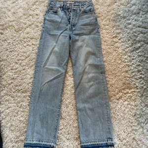 Levi's Ribcage Straight Jeans - Snygga Levi's Ribcage Straight jeans i en klassisk ljusblå färg. Dessa jeans har en hög midja och raka ben. 