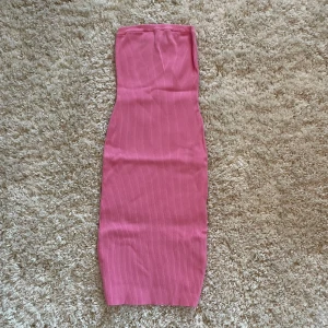 Ribbad off-shoulder klänning  - Säljer en snygg rosa off-shoulder klänning från NA-KD. Den är gjord i ett mjukt och stretchigt material som sitter bekvämt. Använd en gång.