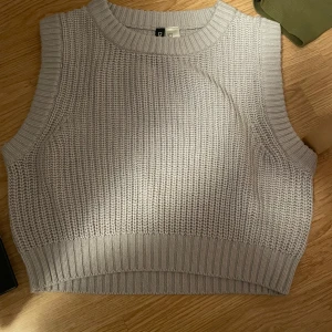 Grå/Lila stickad ärmlös topp från H&M Divided - Säljer en  grå/lila stickad topp från H&M Divided. Den är ärmlös och har en ribbad kant vid hals och nederdel. Perfekt för lager-på-lager eller som den är. 🖤