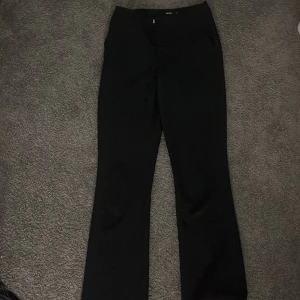 Svarta kostymbyxor från BikBok - Snygga svarta kostymbyxor från BikBok i storlek 36. De är inte så högmidjade men inte låg midjade heller. Säljs pågrund av att de inte kommer till användning. Använda bara ett fåtal gånger ser ut som nya och är inprincip nya.