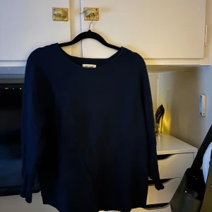 Mörkblå kashmirtröja från Soft Goat - Säljer en elegant mörkblå kashmirtröja från Soft Goat. Tröjan har en klassisk rund hals och långa ärmar, perfekt för kyliga dagar. Den är tillverkad i 100% kashmir vilket gör den extra mjuk och lyxig. Passar perfekt för både vardag och mer uppklädda tillfällen.