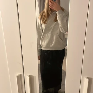 Svart långkjol - Snygg svart långkjol med en elegant vågig kant. Perfekt för en stilren look. Kjolen är enkel att matcha med olika toppar och accessoarer.