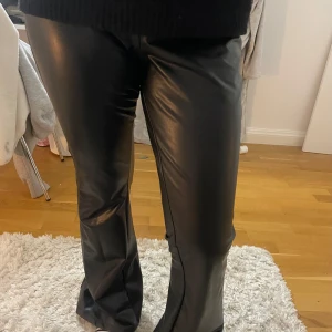 Svarta skinnbyxor - Snygga svarta skinnbyxor med bootcut-stil. De har en tight passform upptill och blir vidare nedtill. Ganska högmidjade men går att vika ner🩷⭐️