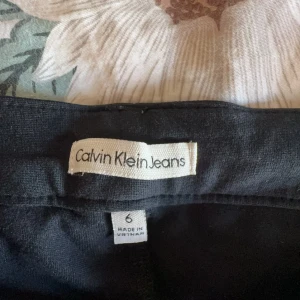 Svarta jeans från Calvin Klein - Snygga svarta jeans från Calvin Klein med en stilren design. De har en klassisk femficksmodell och en knapp med märkets logga. Perfekta för en stilren look.