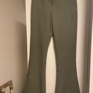 Gröna kostymbyxor  - Oanvända gröna kostymbyxor, lågmidjade med utsvängda ben från Gina Tricot 