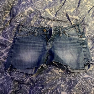 Blå jeansshorts från Crocker - Säljer ett par snygga blå jeansshorts från Crocker. De har en fransig kant och klassisk femficksdesign. Perfekta för en avslappnad stil.