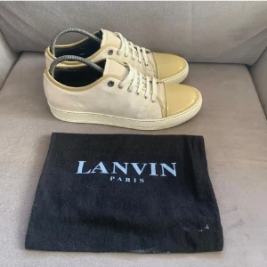 Lanvin Cap Toe - Snygga beige sneakers från Lanvin med glansig tå och snörning. Påse tillkommer! Uk 9/ eu 44