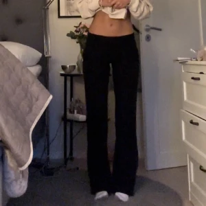 Kostymbyxor  - Snygga svarta byxor med låg midja och bootcut-stil. Perfekta för en stilren look.