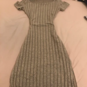 Randig klänning från Shein - Säljer en stilren randig klänning från Shein i en neutral färg. Klänningen har korta ärmar och en rund halsringning, perfekt för en avslappnad look. Materialet är mjukt och bekvämt, vilket gör den idealisk för vardagsbruk.