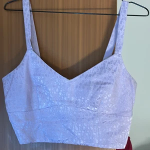 Ljuslila korsett från River Island - Snygg ljuslila korsett från River Island med ett diskret mönster och dragkedja bak. Perfekt för en stilren look.