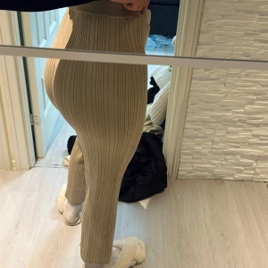 Beige ribbade byxor - Snygga beige ribbade byxor med hög midja och tight passform. Perfekta för en stilren look och bekväma att bära hela dagen. Passar utmärkt till både vardag och mer uppklädda tillfällen. Passar perfekt för m/l/xl storlek 