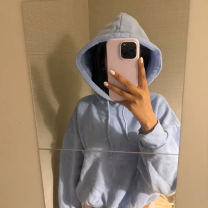 Ljusblå hoodie - Säljer en mysig ljusblå hoodie med luva. Perfekt för en avslappnad stil. Den har långa ärmar och en bekväm passform. Den är lite mer åt det kroppade hållet och jag har lagt till ett resårband vilket man kan se i sista bilden så den ska sitta lite tajtare nertil. Luvan är stor och jätte mysig och en fin himmelsblå färg.