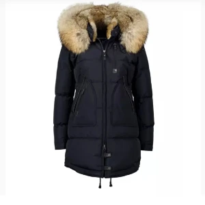 Svart dunjacka med pälsdetalj - Snygg svart dunjacka med stor pälsdetalj på huvan. Jackan har långa ärmar och praktiska dragkedjor framtill. Perfekt för kalla vinterdagar. Det är en äkta päls jacka och märket är Cedrigo. Använd endast några gånger.