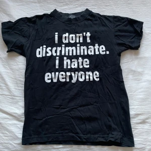 Svart t-shirt med tryck från Rock Metal - Säljer en svart t-shirt från Rock Metal med ett humoristiskt tryck i vitt på framsidan. T-shirten har korta ärmar och en klassisk rund halsringning. Perfekt för dig med en edgy stil!