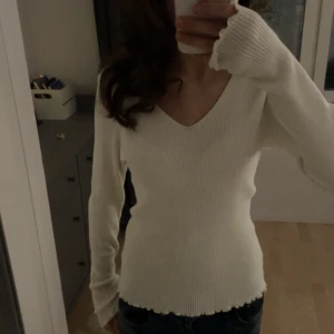 Snygg vit ribbad tröja från Vero Moda - Säljer en  vit ribbad tröja från Vero Moda. Tröjan har en v-ringad design och långa ärmar. Den är mjuk och bekväm, idealisk för både vardag och när man vill vara finklädd💕💕Storlek L men funkar även för M/S