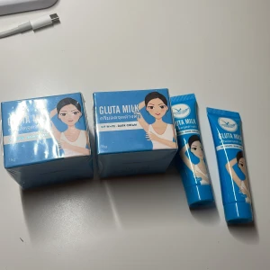 Gluta Milk VIP White Dark Cream - Gluta Milk VIP White Dark Cream i blå förpackning med illustration av en kvinna. Krämen är avsedd för hudvård och kommer i både tub och burk. Perfekt för att ljusa upp och vårda huden. 150kr/ låda och 1 små plastlåda. 