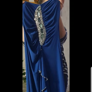 Blå långklänning med pärldetaljer - Elegant blå långklänning med vackra pärldetaljer längs kanten. Ej använd.
