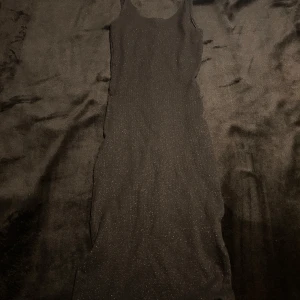 Svart glittrig klänning - Pull&Bear - Snygg svart glittrig klänning från Pull&Bear i storlek XS. Klänningen har en elegant design och är ärmlös, perfekt för festliga tillfällen.