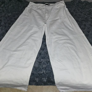 Vita vida byxor - Säljer ett par vita byxor med en loose passform och vida ben. Perfekta för en avslappnad stil.