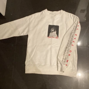 Vit sweatshirt med 2Pac-tryck från Junkyard - Säljer en vit sweatshirt från Junkyard med ett stort 2Pac-tryck på framsidan. Tröjan har texten 'ALL EYEZ ON ME' längs ärmen i rött och en lista med låttitlar. Perfekt för dig som gillar streetwear och musik. Aldrig använt då jag köpte fel storlek.//Nyskick