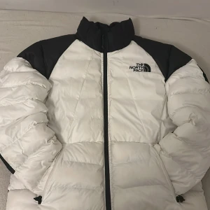 The North Face pufferjacka - En jättefin vit-svart pufferjacka från The North Face. Den är stor och är perfekt för vinterns kalla väder. Priset kan diskuteras.